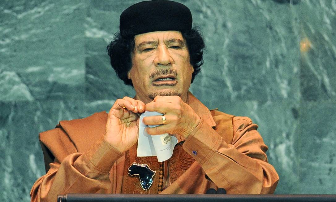 36218667 President Moamer Kadhafi of Libya tears pages from a book as he speaks during the United Na